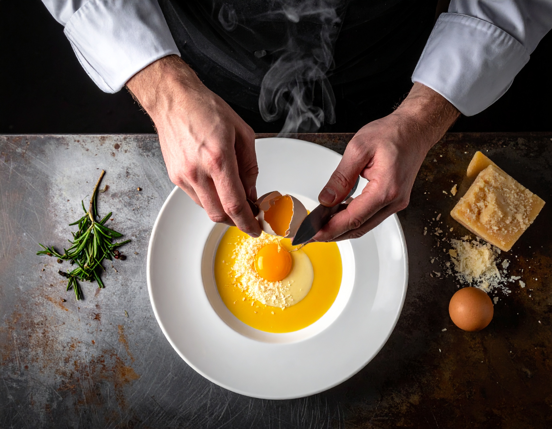 Chef abriendo el huevo a 63°C sobre la crema de parmesano, yema cayendo lentamente