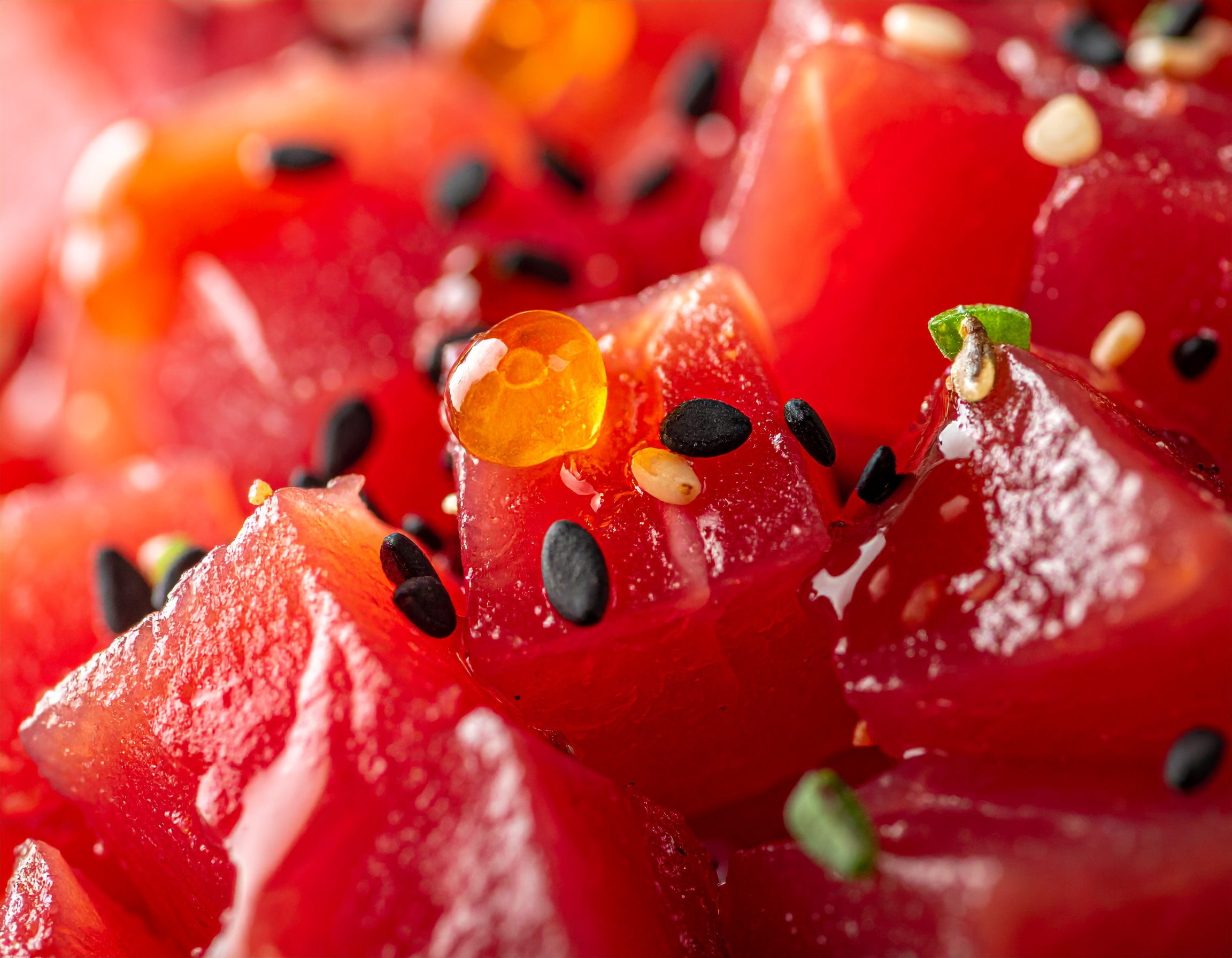 Macro extremo de cubos de atún rojo con caviar de ponzu naranja y sésamo negro
