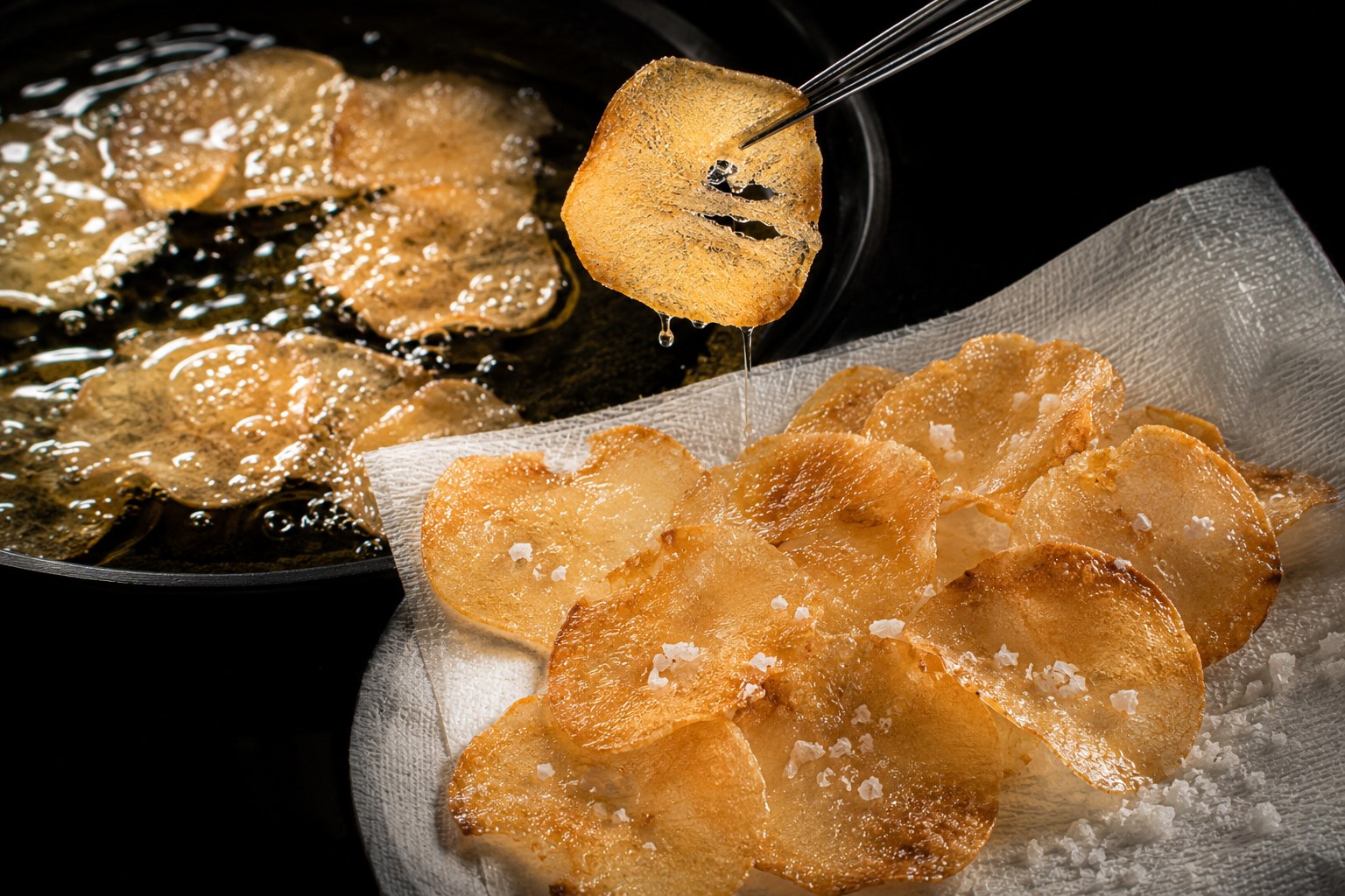 Chips de tuétano friéndose a 180°C hasta dorados y translúcidos