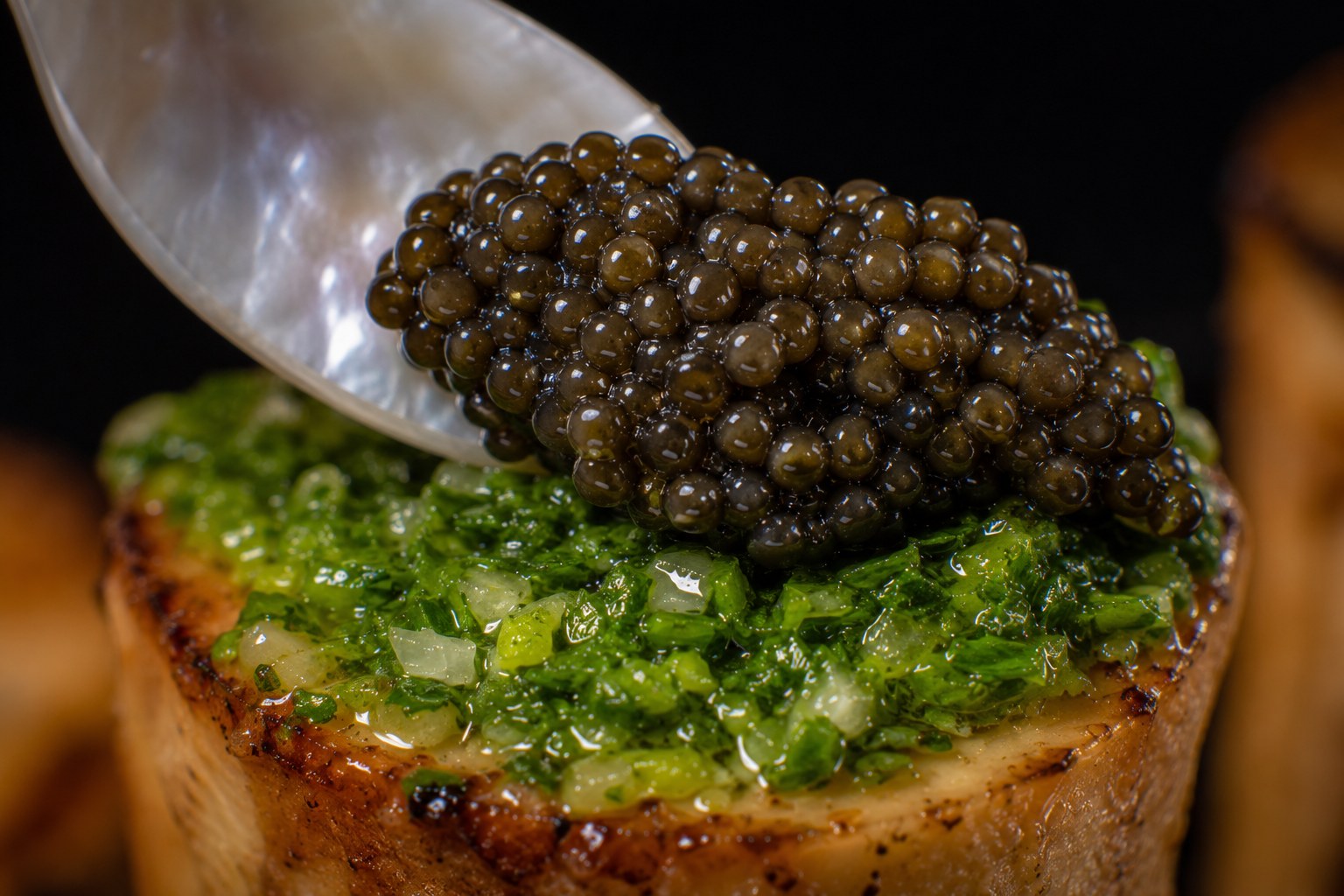Quenelle de caviar Osetra depositándose con cucharita de nácar